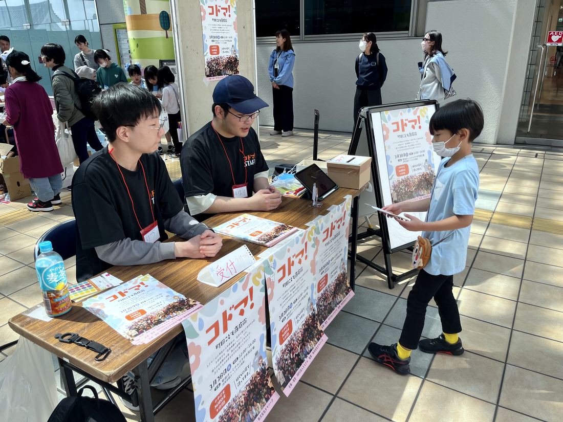 コドマ!の受付で、出店する小学生がスタッフと話している